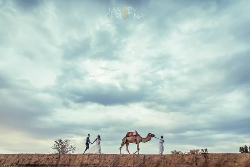 Un couple de jeunes mariés et un chameau dans le désert de Marrakech