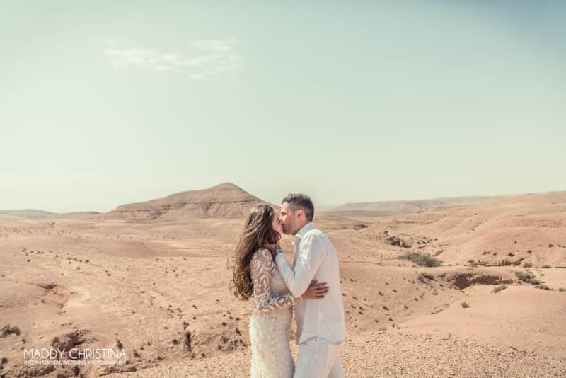 un couple de mariés s’embrassant dans le désert d’Agafay