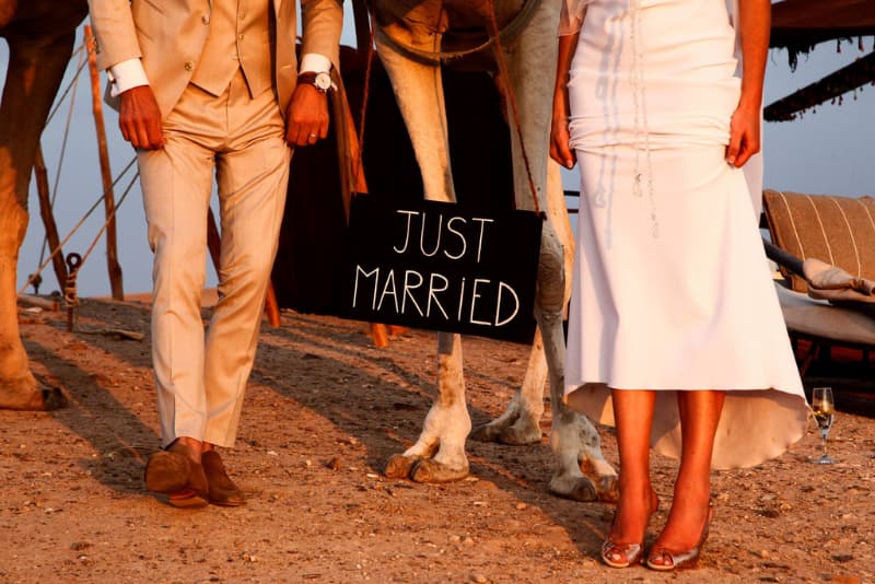 un couple marie avec un signe just married et un chameau