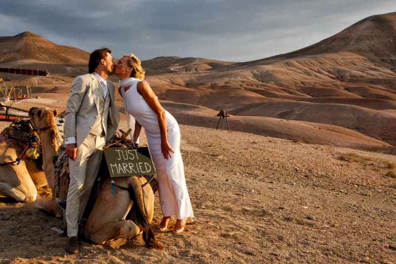 un couple sembrassant sur un chameau en plein desert a marrakech