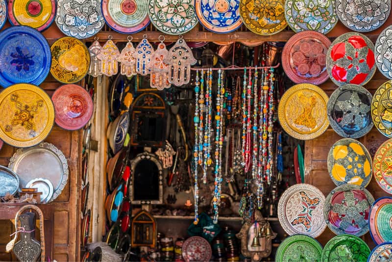 un stand au souk de marrakech decore de bijoux et assiettes colorees